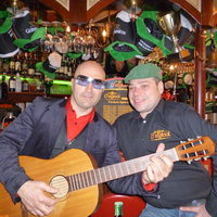 Ein Gitarrist und der Besitzer Herr Fabian sitzen an der Theke