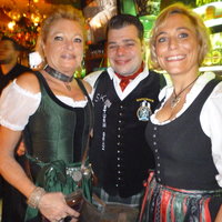 Zwei Frauen in Dirndl und der Besitzer Herr Fabian lachen in die Kamera