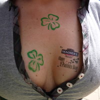 Der Blick in das Dekolleté einer Frau, auf deren Haut das Logo des Pubs gemalt wurde