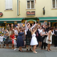 Eine Hochzeitsgesellschaft steht vor dem Pub auf der Straße 